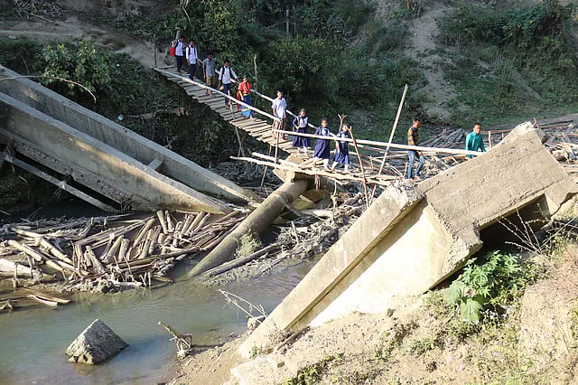 বর্ষায় অস্থায়ী বাঁশের সাঁকো দিয়ে পার হতে চরম ভোগান্তিতে পড়তে হয়।