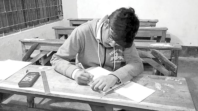 রাতে একা পরীক্ষা দিচ্ছে রিকি হালদার। কুমারখালী পরীক্ষা কেন্দ্রে গতকাল। ছবি: প্রথম আলো