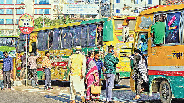ট্রাফিক পশ্চিম বিভাগের ‘বাস থামানো নিষেধ’ লেখা সাইনবোর্ডের পাশে চলছে বাস থামিয়ে যাত্রী ওঠা–নামানো। রোববার মহাখালী উড়ালসড়কে। ছবি: প্রথম আলো