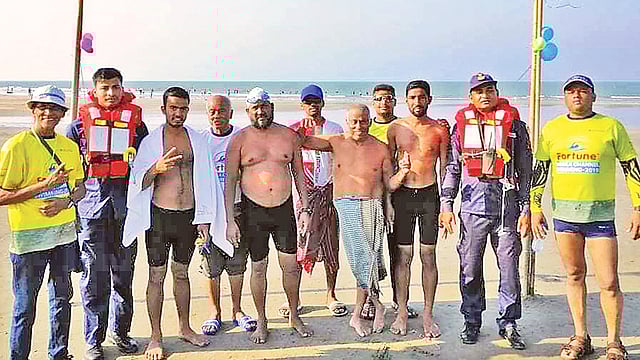 সাঁতরে বাংলা চ্যানেল জয় করলেন ৬৯ বছর বয়সী প্রতিবন্ধী মোহাম্মদ শোয়াইব। (বাঁ থেকে ষষ্ঠ)। গতকাল সেন্ট মার্টিনে। ছবি: প্রথম আলো