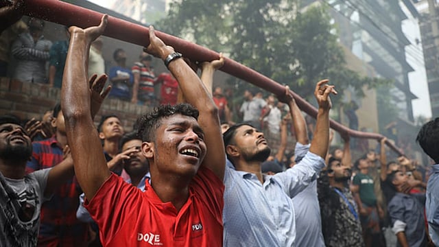 ফায়ার সার্ভিসের পানির পাইপ লাইন উঁচু করে ধরে উদ্ধার কাজে সহযোগিতা করছে সাধারণ মানুষ। বনানী, ঢাকা, ২৮ মার্চ। ছবি: আবদুস সালাম