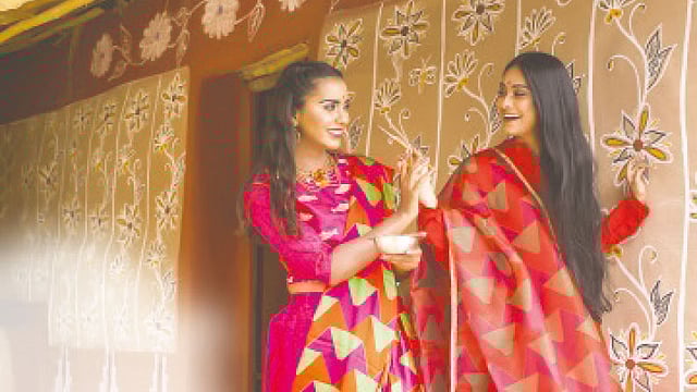 উজ্জ্বল রং, দেশি ঢঙের নকশা—বৈশাখের পোশাক এমনই। পেছনে মাটির েদয়ালে লোকজ নকশা। মডেল: মাইশা ও সায়রা, পোশাক: ক্লাব হাউস, সাজ: অরা বিউটি লাউঞ্জ, গয়না: সিক্স ইয়ার্ডস স্টোরি। স্থান: চাঁপাইনবাবগঞ্জের নাচোলের চিকইল গ্রাম। ছবি: কবির হোসেন
