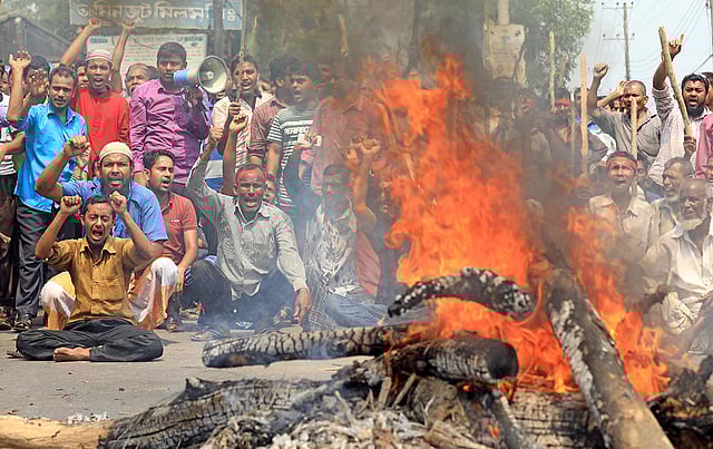 জাতীয় মজুরি কমিশন বাস্তবায়নসহ ৮ দফা দাবিতে আগুন জ্বালিয়ে অবরোধ করে আমিন জুট মিলের শ্রমিকেরা। হাটহাজারী সড়ক, চট্টগ্রাম, ২ এপ্রিল। ছবি: জুয়েল শীল
