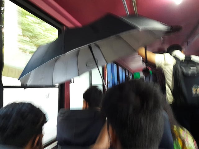 জানালার কাচ ভেঙে পানি ঢুকেছে বাসের ভেতর। বিড়ম্বনায় যাত্রীরা। ছবি: শওকত আলী