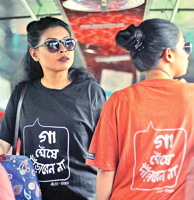 ‘গা ঘেঁষে দাঁড়াবেন না’ টি-শার্ট গায়ে দুজন নারী। ছবি: সংগৃহীত