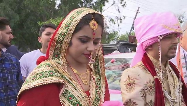 নবদম্পতিকে বিয়ের পোশাকে দেখে অনেকেই সেলফি তুলেছেন। উদমপুর ভোটকেন্দ্র, কাশ্মীর, ভারত, ১৮ এপ্রিল। ছবি: টুইটার