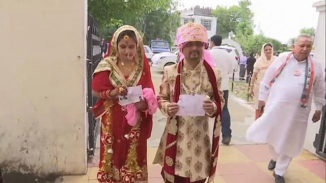 বিয়ের আনুষ্ঠানিকতা সেরেই ভোটকেন্দ্রে চলে যান এই নবদম্পতি। উদমপুর ভোটকেন্দ্র, কাশ্মীর, ভারত, ১৮ এপ্রিল। ছবি: টুইটার