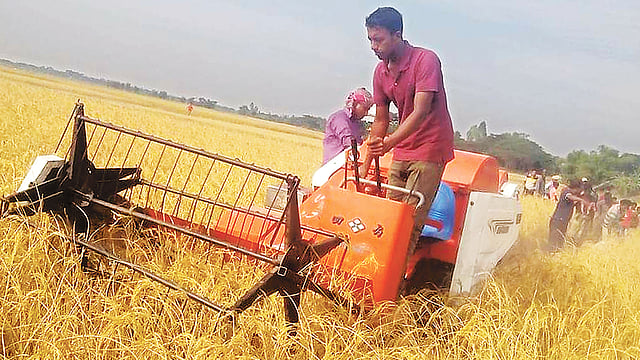 কম্বাইন্ড হারভেস্টর যন্ত্র দিয়ে খেতের ধান কাটা হচ্ছে। গত শনিবার সুনামগঞ্জের জগন্নাথপুর উপজেলার দুলোয়ার হাওরে। ছবি: প্রথম আলো