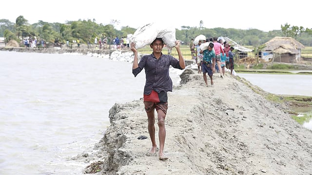 বালুর বস্তা নিয়ে মেরামতের জন্য ছুটে চলা।