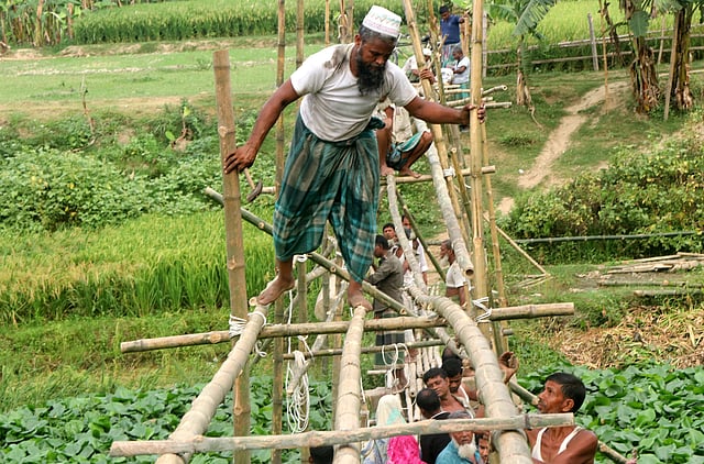 সেতু নির্মাণের সময় বাঁশের ওপর দিয়ে হেঁটে পরীক্ষা করছেন জাহিদুল