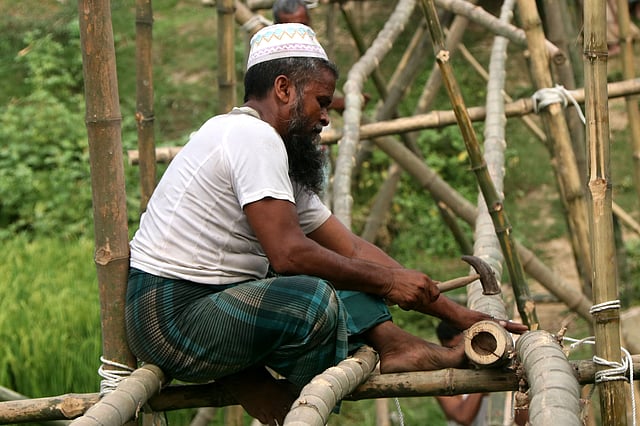গজারিয়া খালের ওপর জাহিদুলের হাতে নির্মিত ১৯৬তম বাঁশের সেতু নির্মাণের জন্য বাঁশ কাটছেন