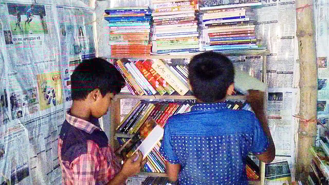 শহীদ মিলন স্মৃতি পাঠাগারে বই খুঁজছে খুদে দুই পাঠক। ছবি: সংগৃহীত