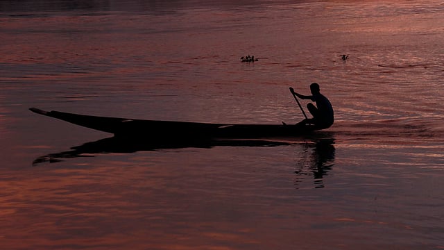 নদের পানিতে নৌকায় মৎস্যজীবী