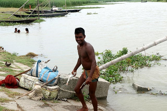 মাছ পেয়ে বেজায় খুশি মৎস্যশিকারি এনামুল শেখ