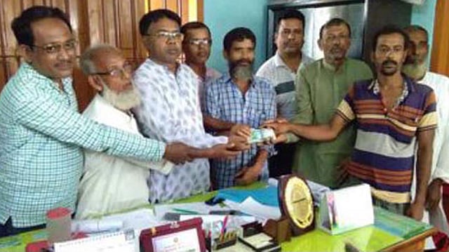 আবদুর রশিদের হাতে হারানো টাকা তুলে দেওয়া হয়। চটপটি বিক্রেতা বেলাল হোসেন (উভয় দিক থেকে ৫ নম্বর)। ছবি: সংগৃহীত