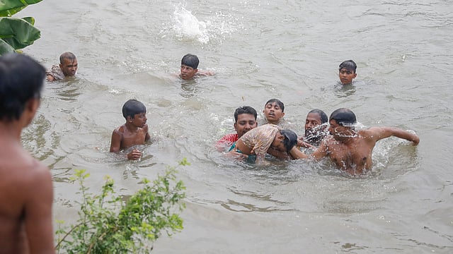 নয় বছরের আয়েশাকে খুঁজতে তুরাগ নদে স্থানীয় লোকজনের তৎপরতা। প্রায় ২০ মিনিট পর আয়েশাকে পানি থেকে উদ্ধার করা হয়। শহীদ সোহরাওয়ার্দী মেডিকেল কলেজ হাসপাতালে নেওয়ার পর চিকিৎসক তাকে মৃত ঘোষণা করেন। ৪ জুলাই, ঢাকা। ছবি: আশরাফুল আলম