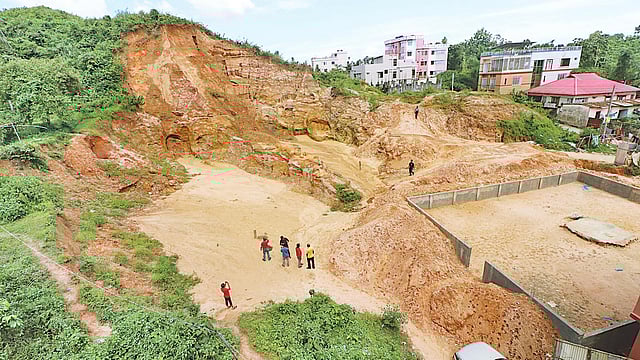 প্রবেশপথে ছিল টিনের বেড়ার একটি ফটক। ফটকের আড়ালে কাটা হয়েছে টিলার এই অংশ। গত শনিবার সিলেট নগরের মজুমদার টিলার ব্রাহ্মণশাসন এলাকায়। ছবি: প্রথম আলো