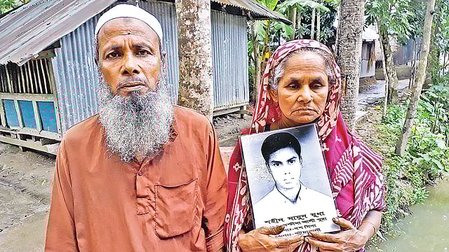 মামুনের ছবি হাতে বাবা মোতালেব মৃধা ও মা মোর্শেদা বেগম। ছবি: প্রথম আলো