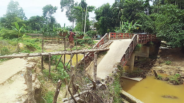 বাঁশখালীর পুঁইছড়ি ইউনিয়নের নাপিত বিল খালের ওপর নির্মিত সেতুটির ২০ ফুট অংশ ধসে গেছে ১১ মাস আগে। এখনো সেতুটি সংস্কারের কোনো উদ্যোগ নেওয়া হয়নি। সাঁকো তৈরি করে ঝুঁকি নিয়ে সেতুটি ব্যবহার করছেন স্থানীয় লোকজন। গতকাল দুপুরে। প্রথম আলো
