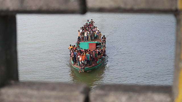 নৌকায় চড়ে নৌকাবাইচ উপভোগ।