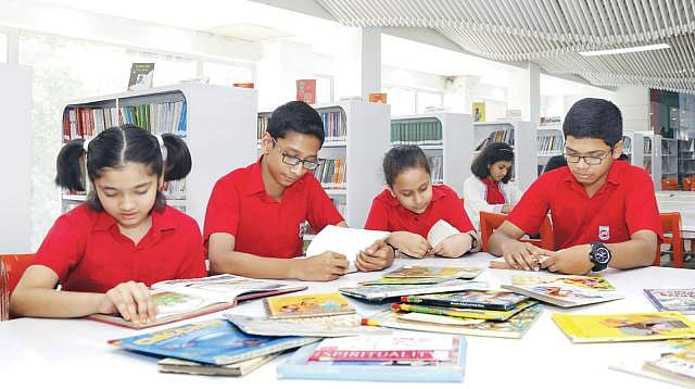 বাংলাদেশ শিশু একাডেমির গ্রন্থাগারে বইয়ের জগতে ডুবে রয়েছে কয়েকজন শিশু। ফাইল ছবি