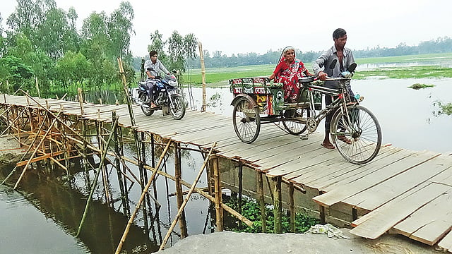 ঝুঁকি নিয়ে চলছে মোটরসাইকেলসহ অন্য যানবাহন। সম্প্রতি সাঘাটার বাটি গ্রামে। প্রথম আলো