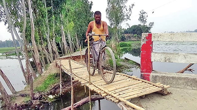 বাঁশের সাঁকো দিয়ে হেঁটে পার করা হচ্ছে সাইকেল। সাঘাটার পূর্ব বাটি এলাকায়। প্রথম আলো