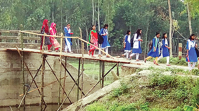 একটি সেতুর সংযোগ সাঁকো দিয়ে ঝুঁকি নিয়ে পার হচ্ছে শিক্ষার্থীরা। সম্প্রতি সাঘাটার পশ্চিম বাটি গ্রামে। ছবি: প্রথম আলো