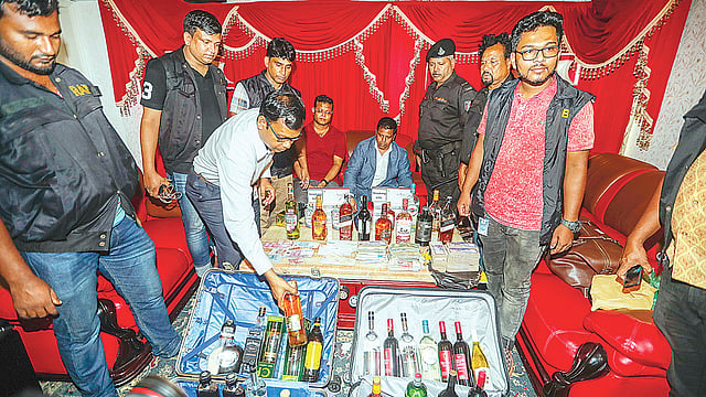 বিপুল পরিমাণ মদ ও টাকাসহ সেলিম প্রধান ও তাঁর সহযোগী আক্তারুজ্জামানকে (লাল গেঞ্জি পরা) আটক করে র্যাব। গতকাল গুলশান-২-এ সেলিম প্রধানের কার্যালয়ে। ছবি: প্রথম আলো