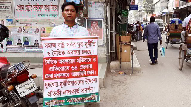 ঘুষ, দুর্নীতি ও নৈতিক অবক্ষয়ের প্রতিবাদে বুকে ব্যানার নিয়ে হানিফ বাংলাদেশী। প্রেসক্লাব প্রাঙ্গণ, মানিকগঞ্জ, ১৫ অক্টোবর। ছবি: আব্দুল মোমিন