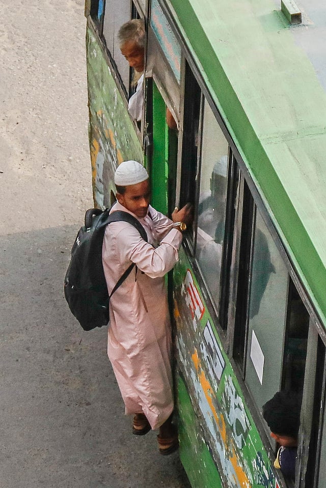 গেট বন্ধ থাকা সত্ত্বেও ঝুলে যাচ্ছে এই যাত্রী। বাংলামোটর এলাকায় দুপুরের
