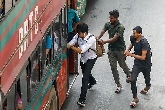 বাংলামোটরের ব্যস্ত সড়কে ঝুঁকি নিয়ে দৌড়ে বিআরটিসি বাসে ওঠার চেষ্টা করছে দুই যাত্রী