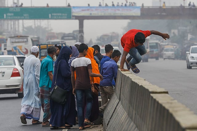 অদূরে পদচারী–সেতু থাকা সত্ত্বেও সড়ক বিভাজক গলে পারাপার। দনিয়া এলাকায়