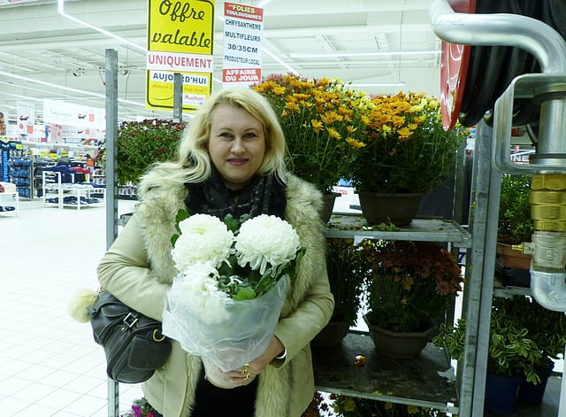 চন্দ্রমল্লিকা হাতে ফুলের দোকানে এক ফরাসি নারী। ছবি: লেখক