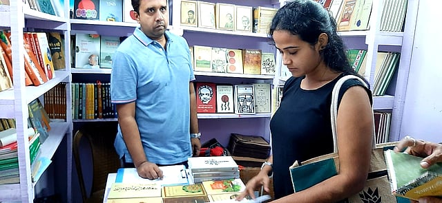 বইমেলায় বই দেখছেন পাঠক। ছবি: ভাস্কর মুখার্জি