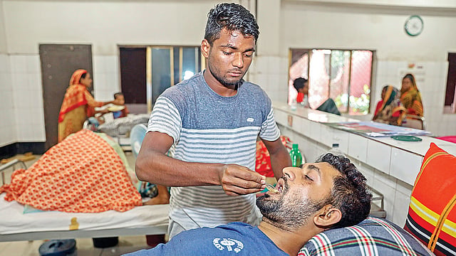 ব্রাহ্মণবাড়িয়ার কসবায় ট্রেন দুর্ঘটনায় আহত সোহেল মিয়াকে ওষুধ খাইয়ে দিচ্ছেন তাঁর ভাই। গতকাল দুপুরে জাতীয় অর্থোপেডিক হাসপাতাল ও পুনর্বাসন প্রতিষ্ঠানে। ছবি: প্রথম আলো