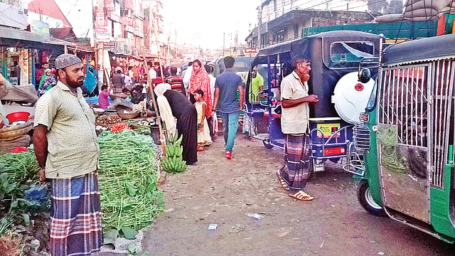 রাস্তার পাশে পণ্যের পসরা সাজিয়ে বসেছেন দোকানিরা। গতকাল বিকেলে ময়মনসিংহের ভালুকা পৌরসভার পাঁচ রাস্তার মোড়ে। ছবি: প্রথম আলো