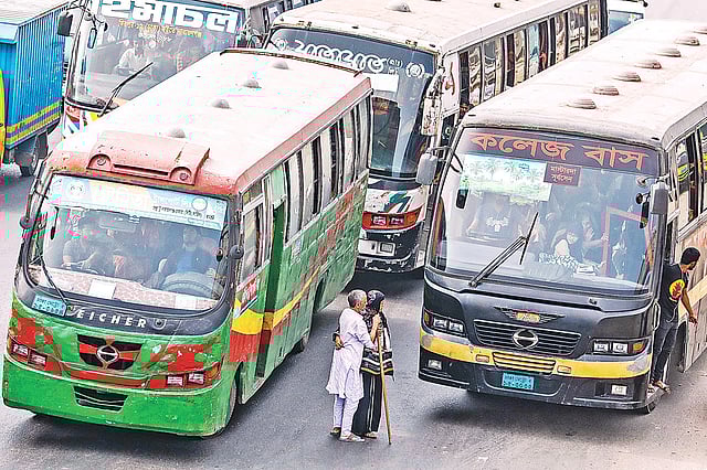প্রতিযোগিতা করে আগে যেতে গিয়ে বৃদ্ধ দুই যাত্রীকে নামিয়ে দেওয়া হয়েছে মাঝসড়কে। পাশ দিয়ে অন্য একটি বাস চলে এলে সড়কে তাঁরা একে অপরকে আঁকড়ে ধরেন। গতকাল বেলা পৌনে দুইটায় রাজধানীর দনিয়ায়। ছবি: দীপু মালাকার