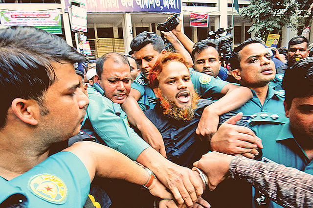 রায় শেষে হোলি আর্টিজান হামলা মামলার আসামি রাজীব গান্ধী ওরফে জাহাঙ্গীর হোসেনকে আদালত থেকে কারাগারে নিয়ে যাচ্ছে পুলিশ। গতকাল ঢাকার সন্ত্রাসবিরোধী বিশেষ ট্রাইব্যুনাল প্রাঙ্গণে। ছবি: হাসান রাজা