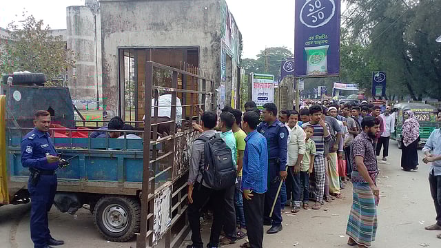 নোয়াখালী শহরের শিল্পকলা একাডেমির ফটকে টিসিবির পেঁয়াজ বিক্রির সময় ভিড় সামলাতে আছে পুলিশ। ছবি: প্রথম আলো