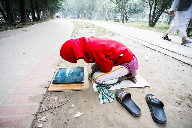 পার্কে ওজন মাপে শিশু স্বপন। খোলা আকাশের নিচে শীত থেকে বাঁচতে গুটিসুটি মেরে বসে আছে সে