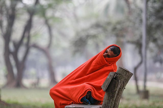 শীতে কম্বল মুড়ি দিয়ে বসে আছে একজন
