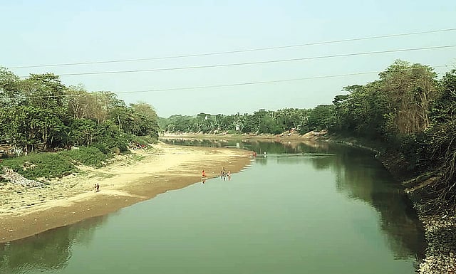 খননকাজ থেমে যাওয়ায় মনু নদে চর জেগে উঠেছে। গতকাল মৌলভীবাজার শহরের চাঁদনীঘাট এলাকায়। ছবি: প্রথম আলো