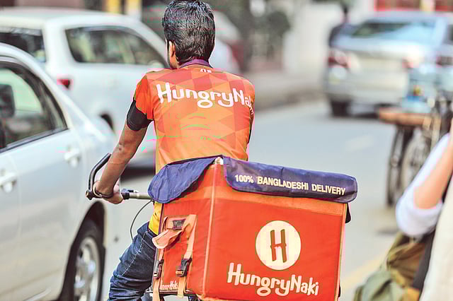 খাবার পৌঁছে দিচ্ছেন হাংরিনাকির এক কর্মী। ছবি: সাইফুল ইসলাম