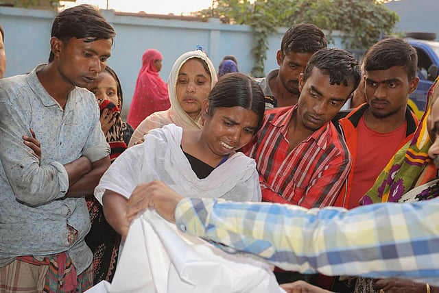 কাজ করতে গিয়ে বিদ্যুতায়িত হয়ে নিহত স্বজনকে দেখে শোকাহত তিনি। ছবি: জাহেদুল করিম