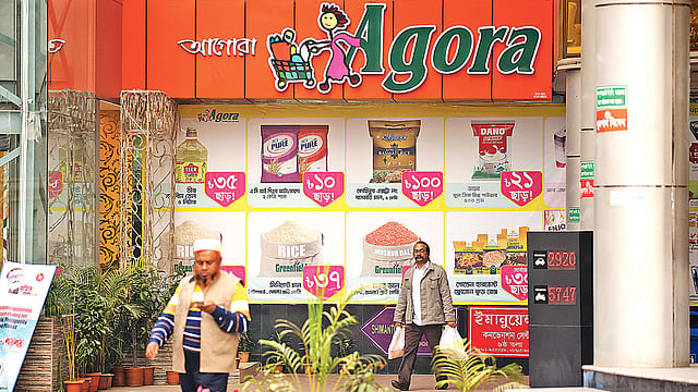 দেশের প্রথম সুপারশপ আগোরা বিক্রি হয়ে যাচ্ছে। ঢাকা, চট্টগ্রাম ও সিলেটে তাদের ১৭টি বিপণি বা স্টোর রয়েছে। ঢাকার সীমান্ত স্কয়ারের আগোরা থেকে কেনাকাটা করে বের হচ্ছেন ক্রেতারা। গতকাল বিকেলে। ছবি: প্রথম আলো