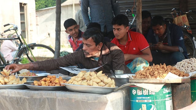 শিঙাড়াসহ তেলে ভাজা নানা ধরনের খাবার নিয়ে বসে আছেন দোকানি। সম্প্রতি মাগুরা সদরের গাংনালিয়া বাজারে। ছবি: প্রথম আলো