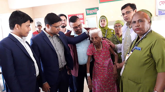 ঢাকা-চট্টগ্রাম মহাসড়কের পাশে ফেলে যাওয়া বৃদ্ধার দায়িত্ব নিলেন দাউদকান্দি উপজেলা নির্বাহী কর্মকর্তা কামরুল ইসলাম খান। আজ মঙ্গলবার বেলা ১১টার দিকে দাউদকান্দি উপজেলা স্বাস্থ্য কমপ্লেক্স থেকে তোলা। ছবি: প্রথম আলো