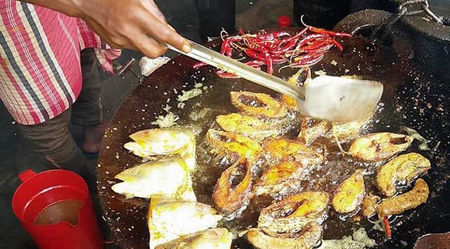 কড়াইতে ভাজা হচ্ছে ইলিশ-বেগুন। ছবি: লেখক