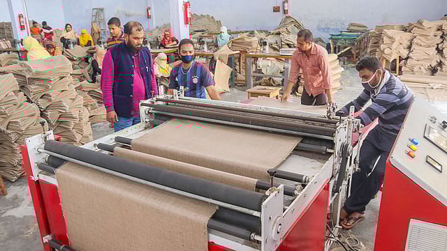 খুলনার ক্রিসেন্ট জুট মিলসের লেমিনেশন প্লান্টে বস্তা তৈরি করছেন শ্রমিকেরা। প্রথম আলো
